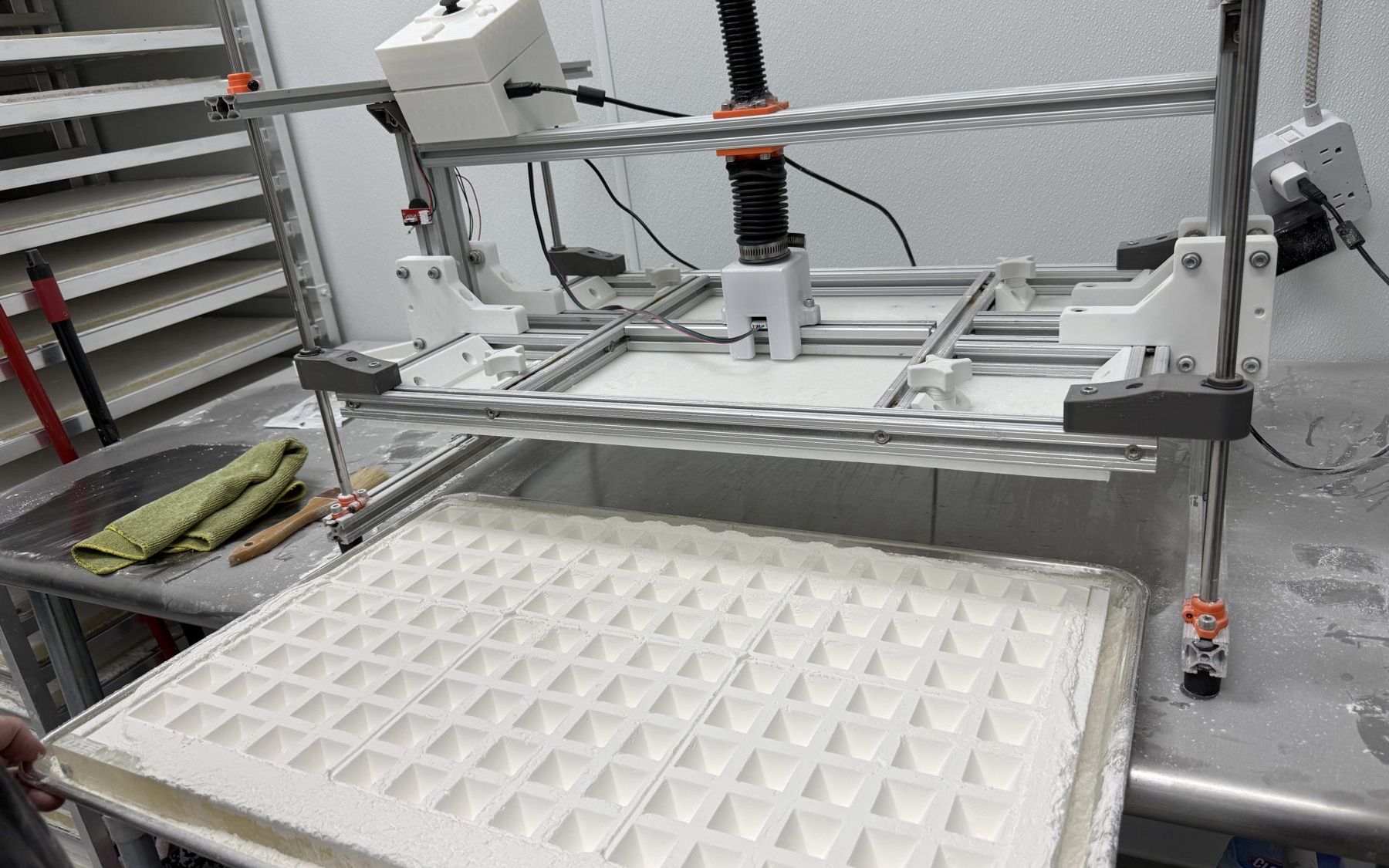 A freshly pressed starch bed, a full grid of crisp cavities, with the press behind it