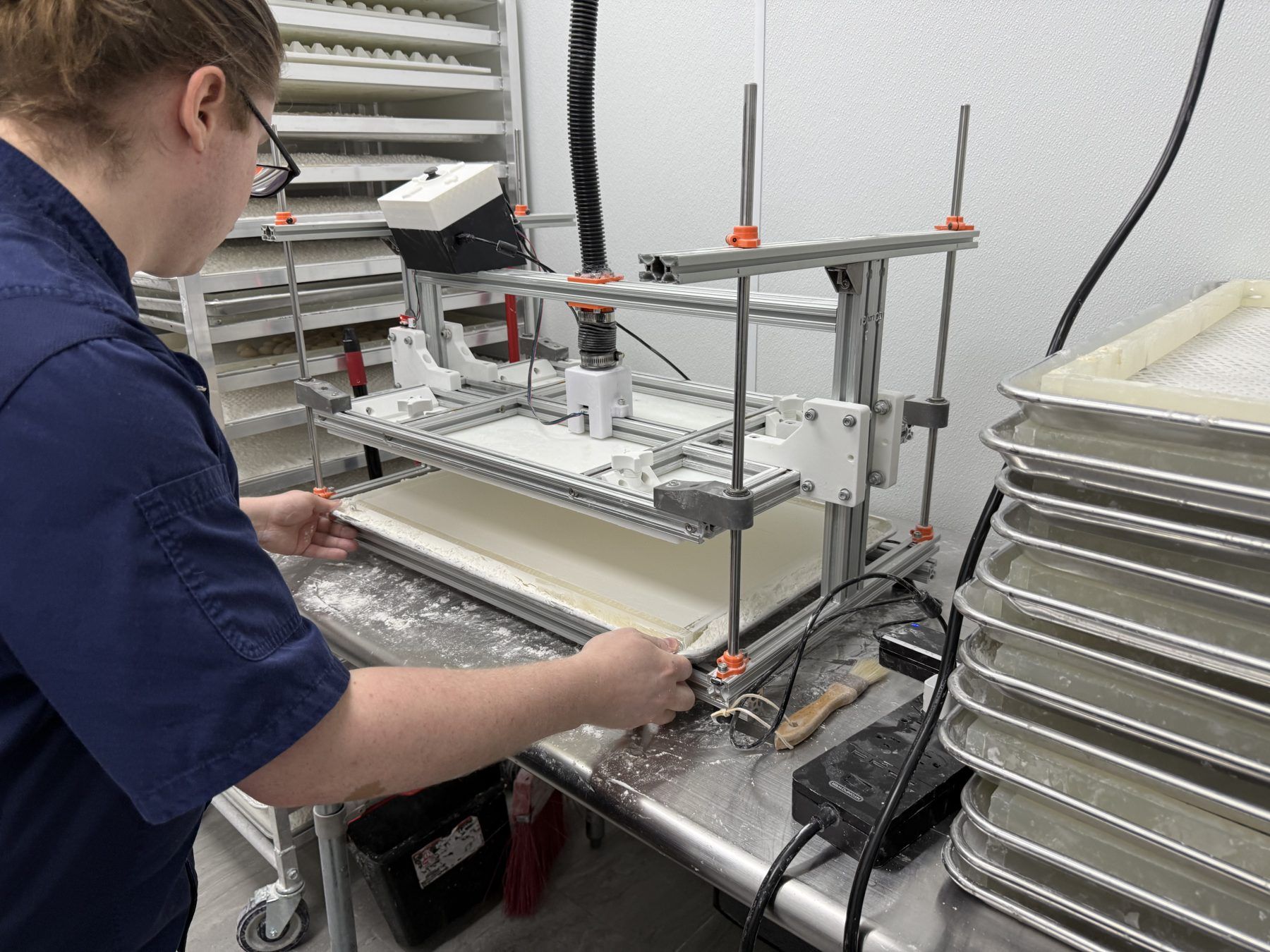 An operator loading a mold frame under the press at the shop