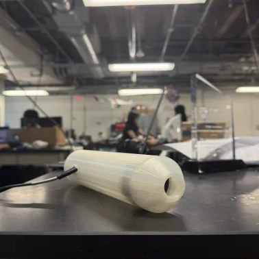 the final handheld retinex prototype on a bench with the fiber-optic cable exiting the rear