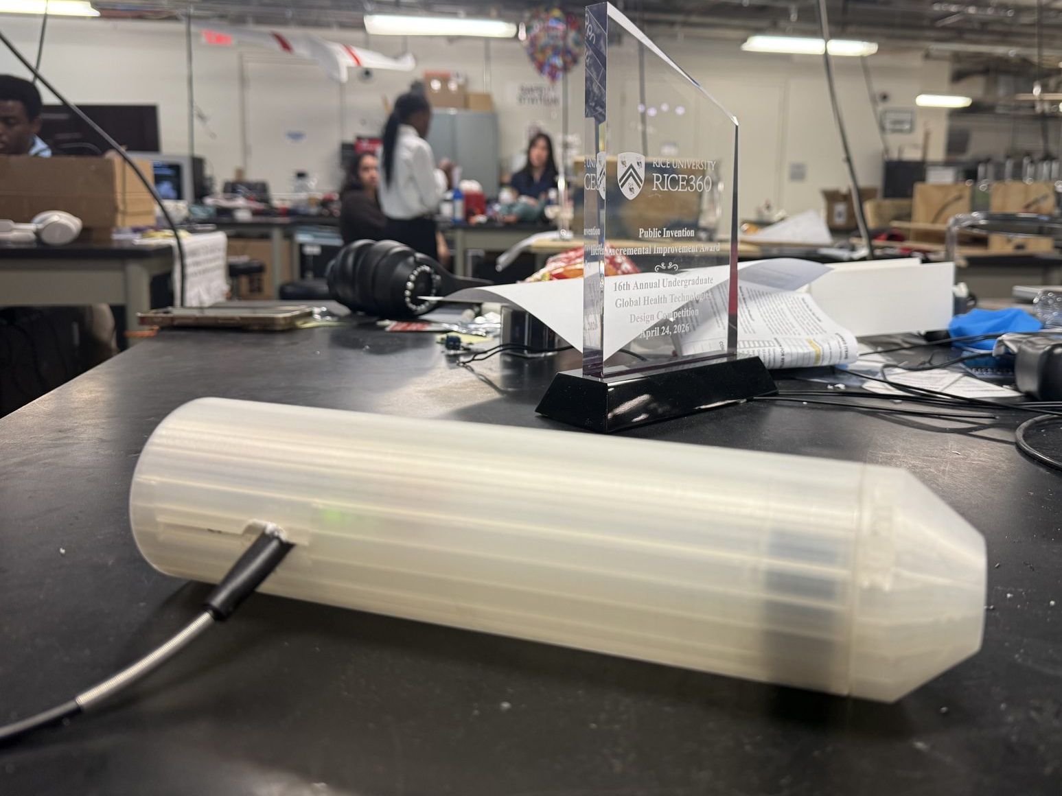 The finished handheld Retinex device on the bench with the Rice 360 award behind it