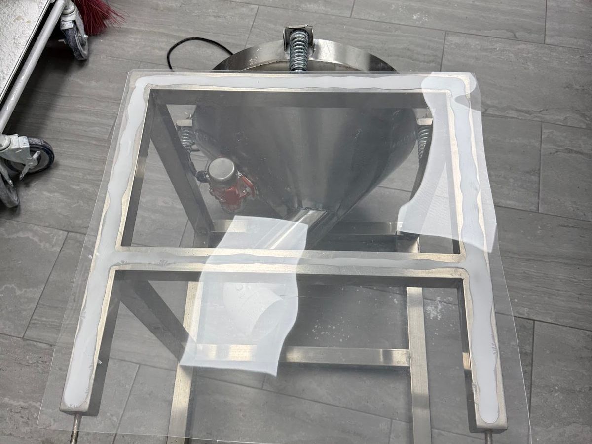 The sealed powder sifting enclosure showing its hinge and latch
